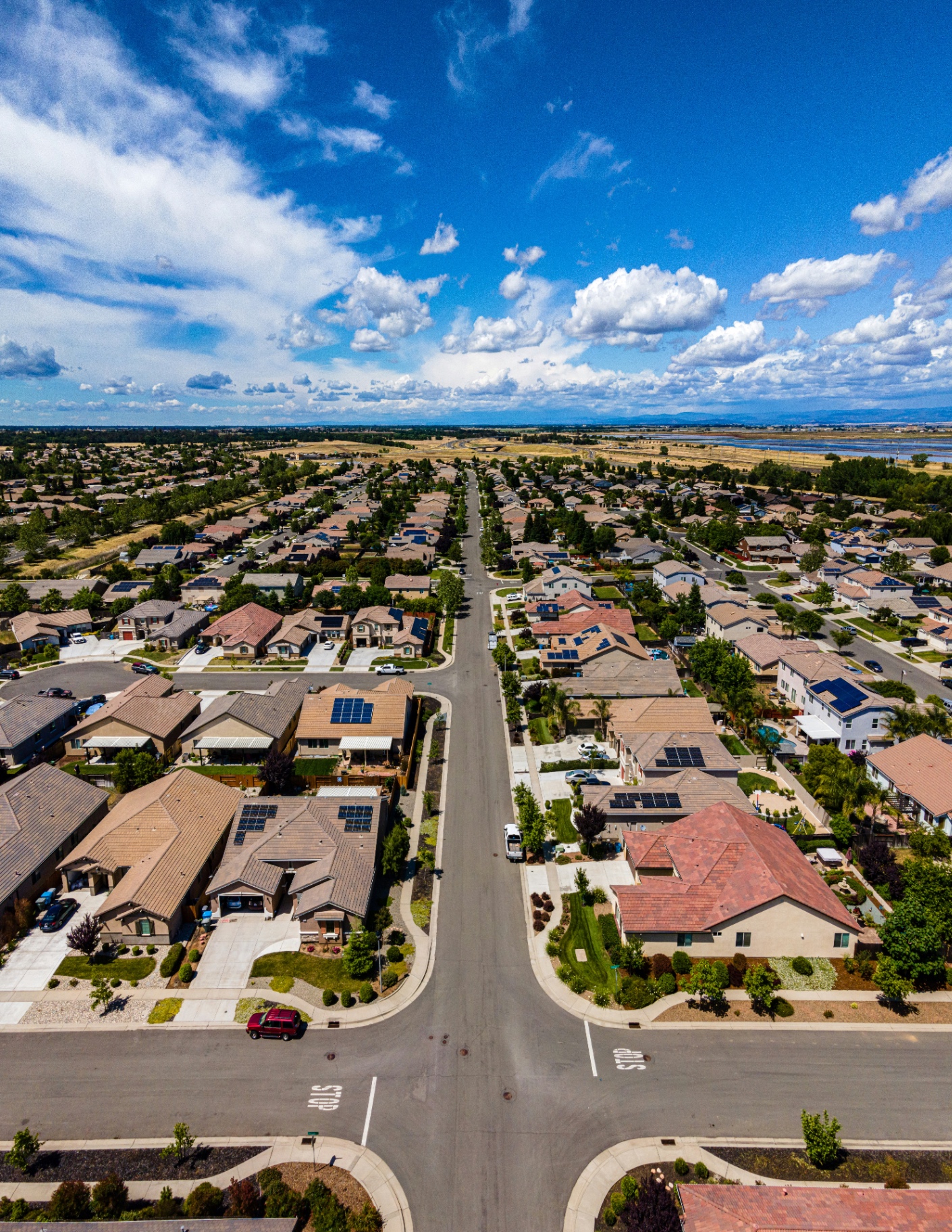 Aerial drone view straight down at a dense residential neighborhood with a street intersection centered